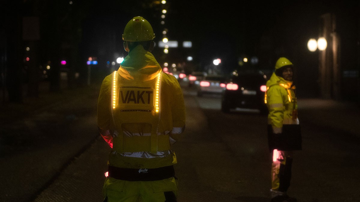Lysande varselvästar på två personer i mörker