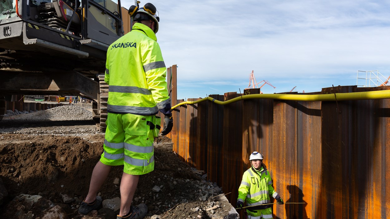 Två byggarbetare pratar med varandra i projekt Packhuskajen i Göteborg. 