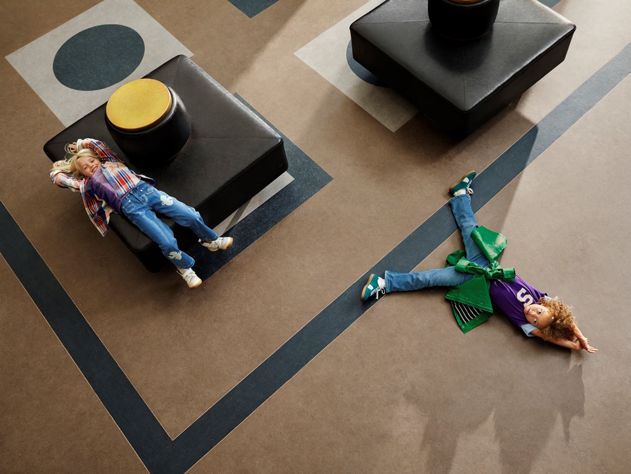 Två barn som ligger på ett golv 2000x1500