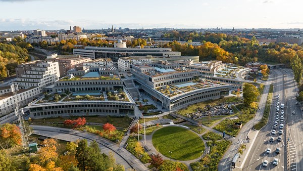 Drönarvy över campusbyggnader och gröna ytor med intilliggande vägar.